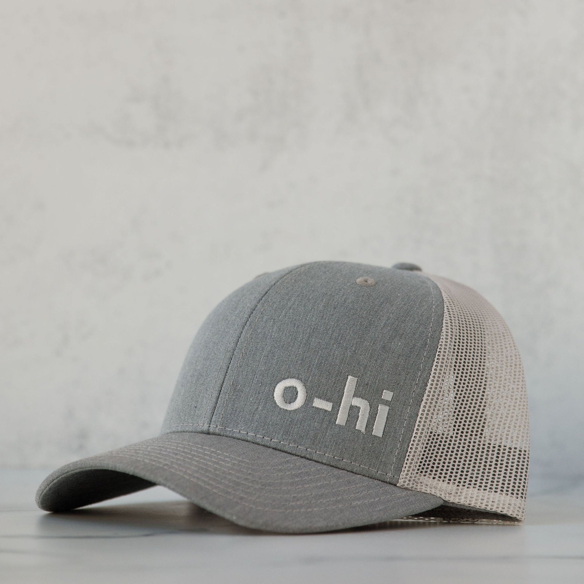A gray o-hi baseball cap with a breathable mesh fabric and an adjustable back strap.
