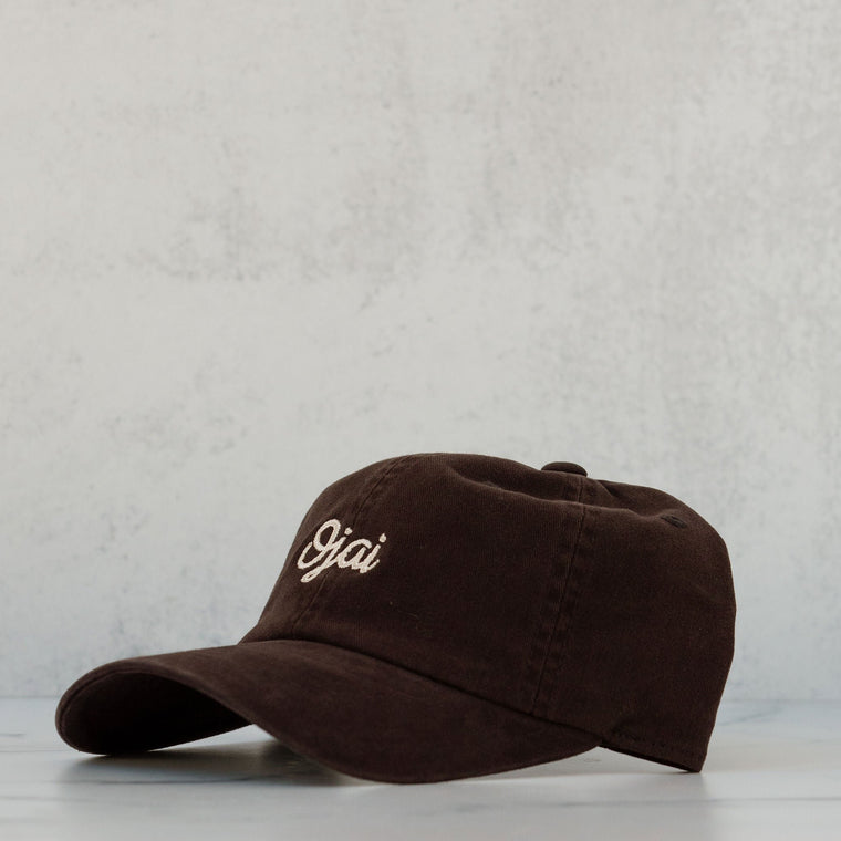 ojai cursive hat white lettering black fabric against a neutral background