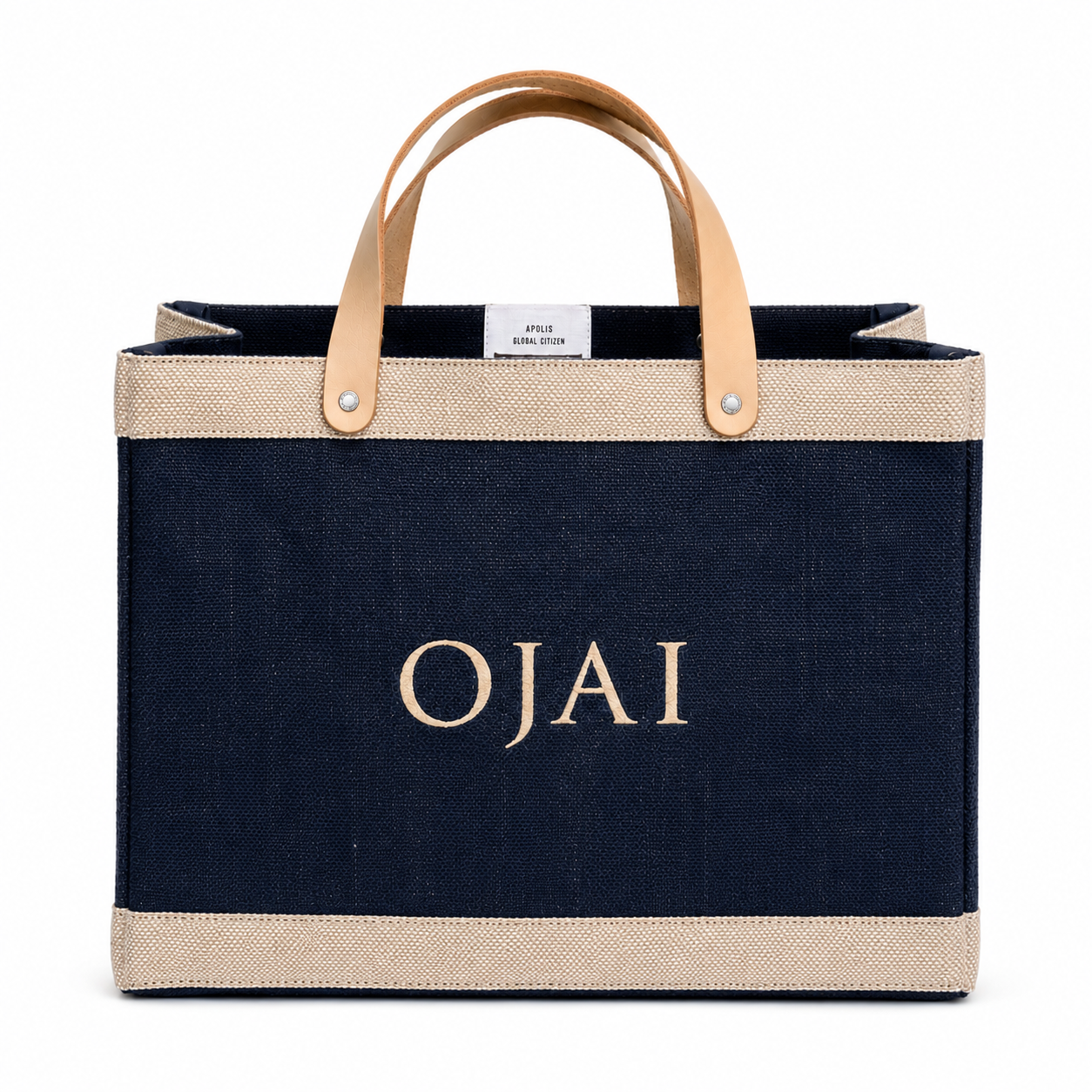 A navy blue canvas tote bag with beige jute trim and light tan leather handles, featuring the name 'OJAI' embroidered in beige on the front.