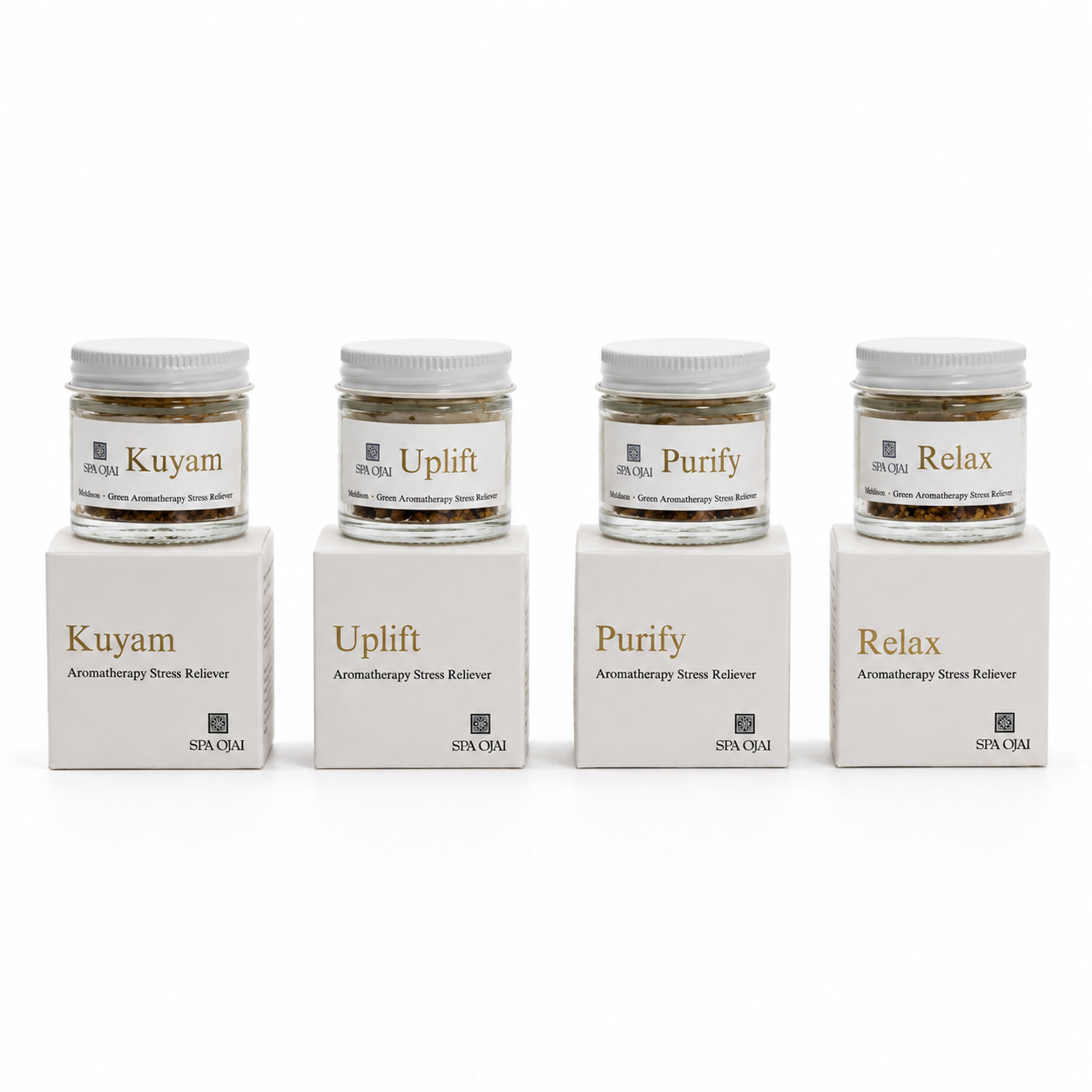 Four small glass jars of spa ojai aromatherapy stone salves with white lids, displayed on top of their matching white cardboard boxes.