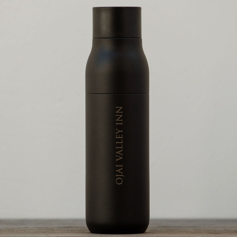 A black insulated stainless steel water bottle with a twist top, labeled 'Ojai Valley Inn'.