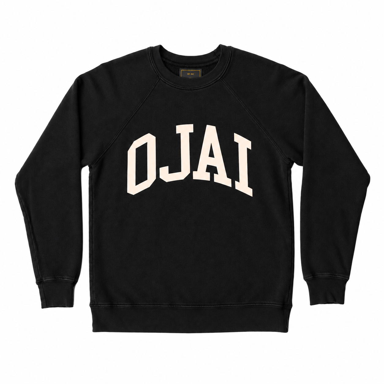 A black crewneck sweatshirt with 'OJAI' printed in a large, arched cream-colored varsity font across the chest, displayed flat against a solid white background.