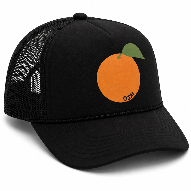 A black trucker-style cap with a mesh back and a graphic of an orange with a green leaf on the front. The word 'NCO' is printed in black on the side of the orange graphic.