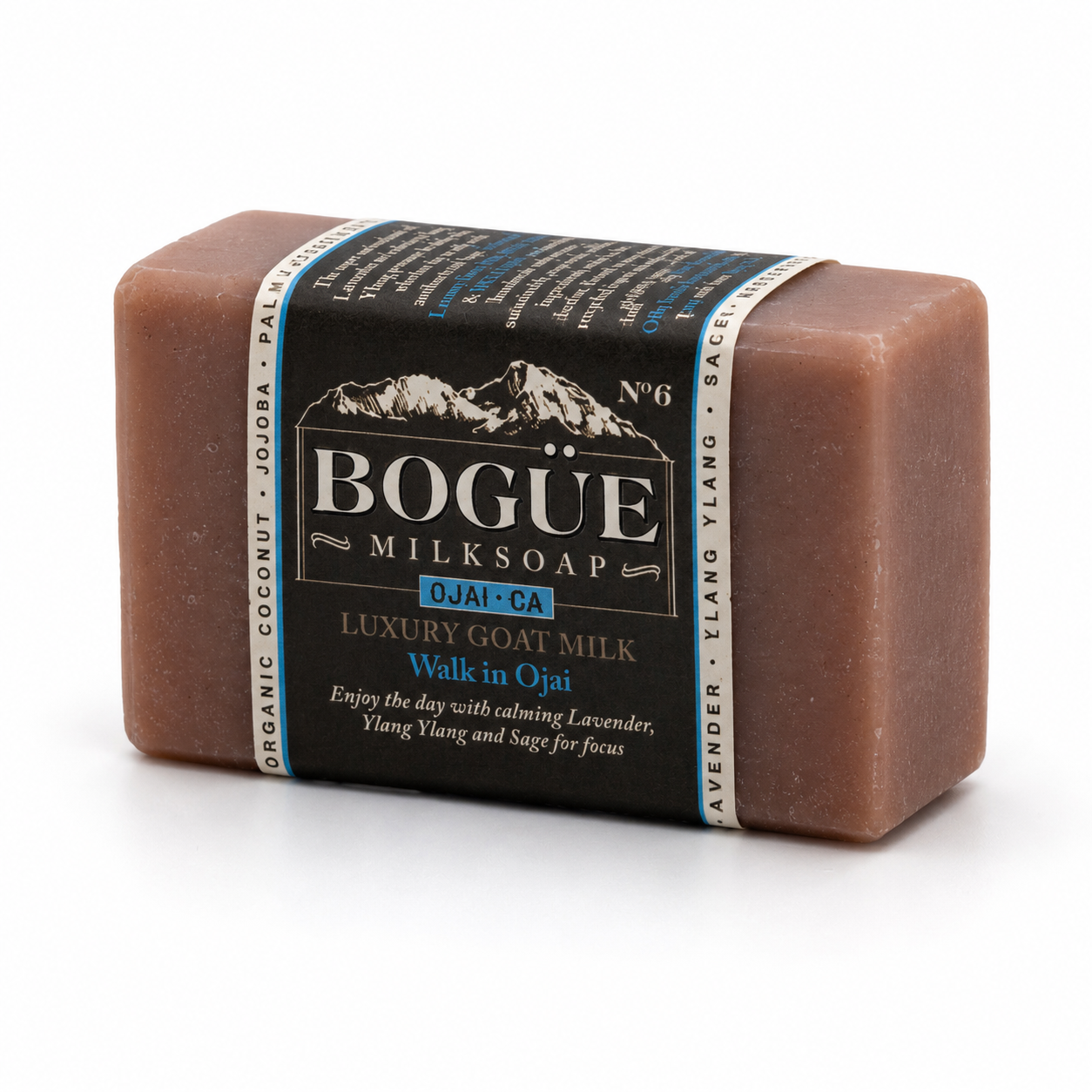 A rectangular bar of Bogue Milksoap Luxury Goat Milk soap in the scent Walk in Ojati, wrapped in a black paper band with white and blue text, on a clean white background.