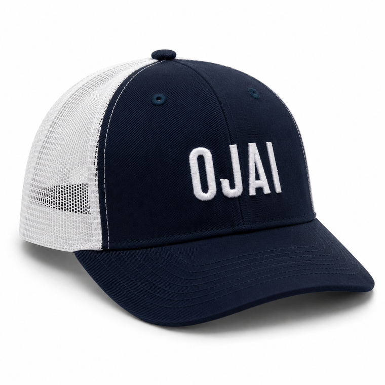 A navy blue and white trucker hat with 'OJAI' embroidered in white on the front, shown on a clean white background.