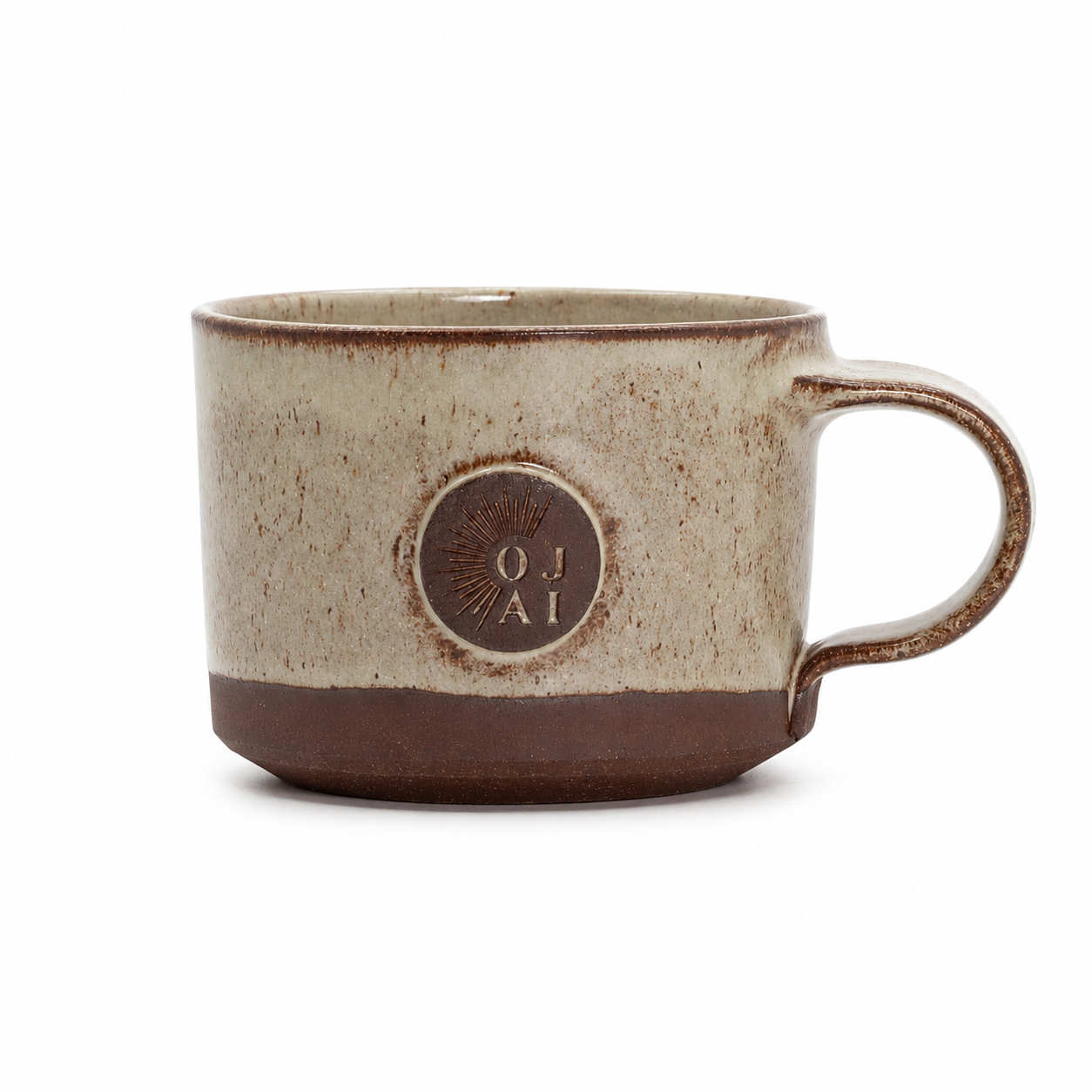 A handmade ceramic mug with a speckled beige and brown glaze, featuring a circular embossed logo on the front that reads 'OJ AI'.