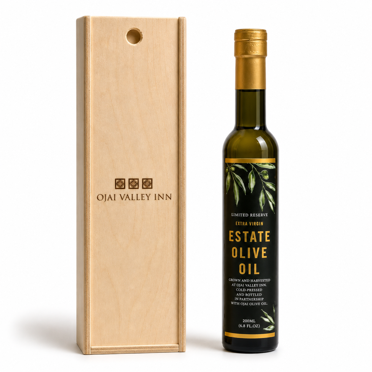 A bottle of Estate Olive Oil next to its light wood presentation box, both featuring the Ojai Valley Inn branding, on a clean white background.