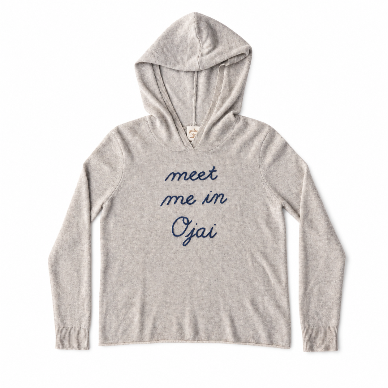 A light heather gray hooded sweatshirt with the phrase 'meet me in Oyai' printed in navy blue script across the chest, displayed flat against a white background.