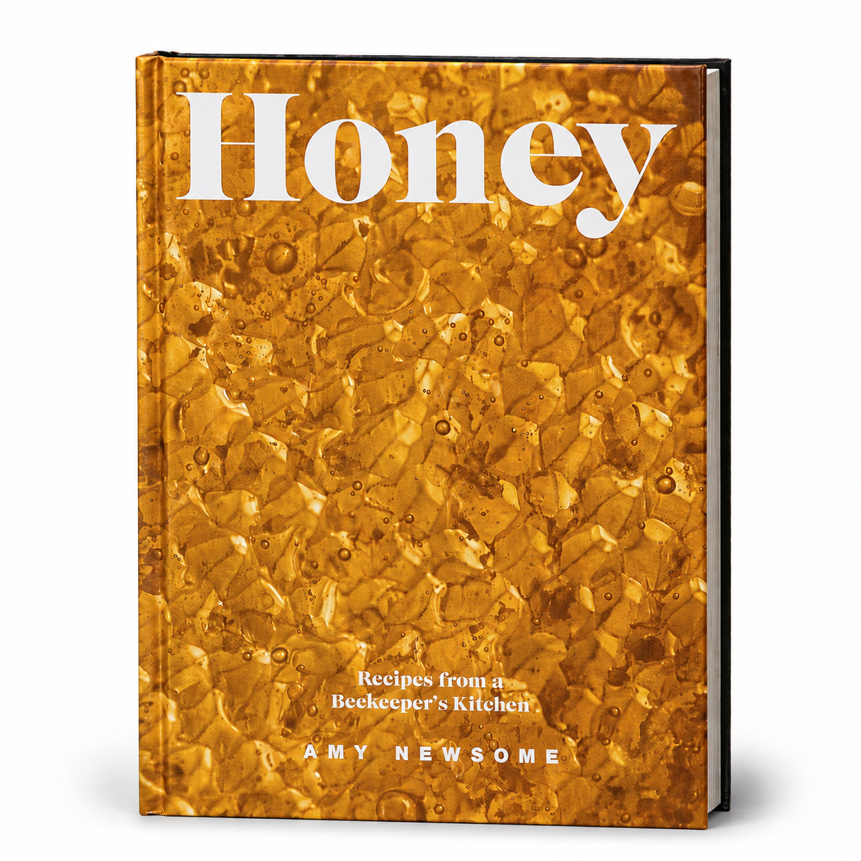 The front cover of the hardcover book 'Honey: Recipes from a Beekeeper's Kitchen' by Amy Newsome, featuring a textured golden-amber honeycomb pattern with the title in large white serif lettering.