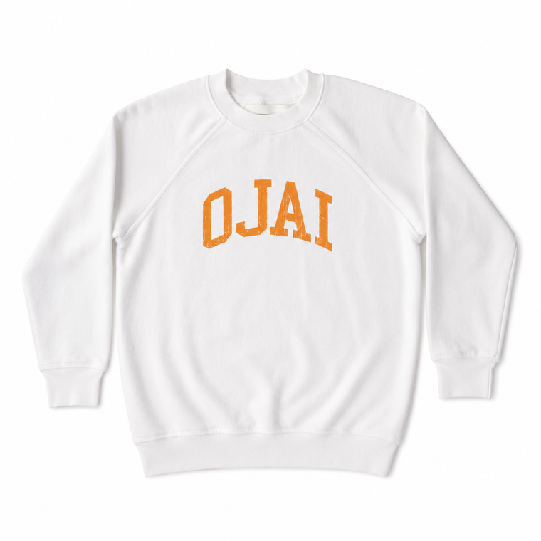 A white crewneck sweatshirt with 'OJAI' printed in an orange arched varsity font across the chest, displayed on a clean white background.