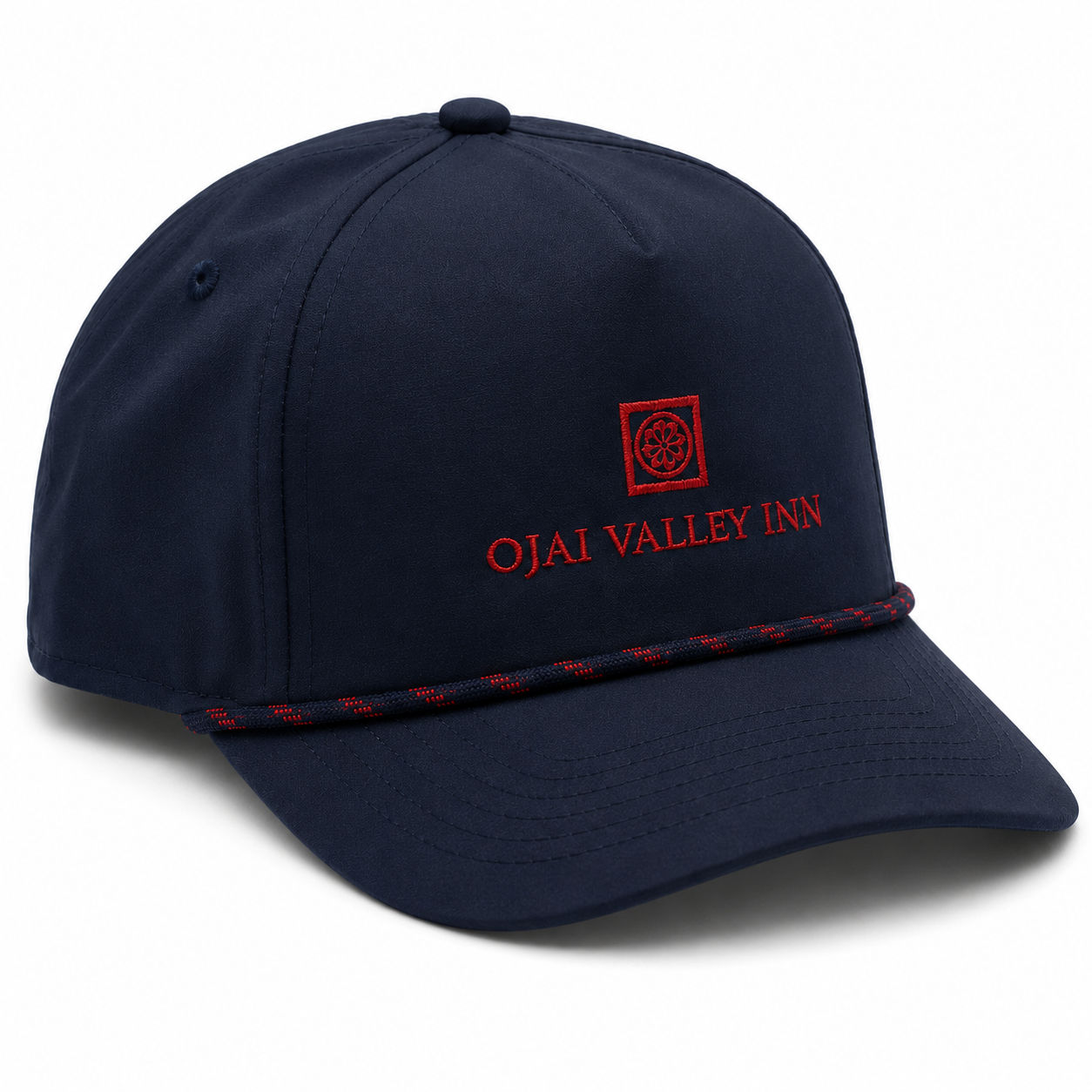 A navy blue baseball cap with red embroidered text reading 'OJAI VALLEY INN' and a red square logo on the front, plus a red-and-navy braided trim along the edge of the brim, shown on a white background.