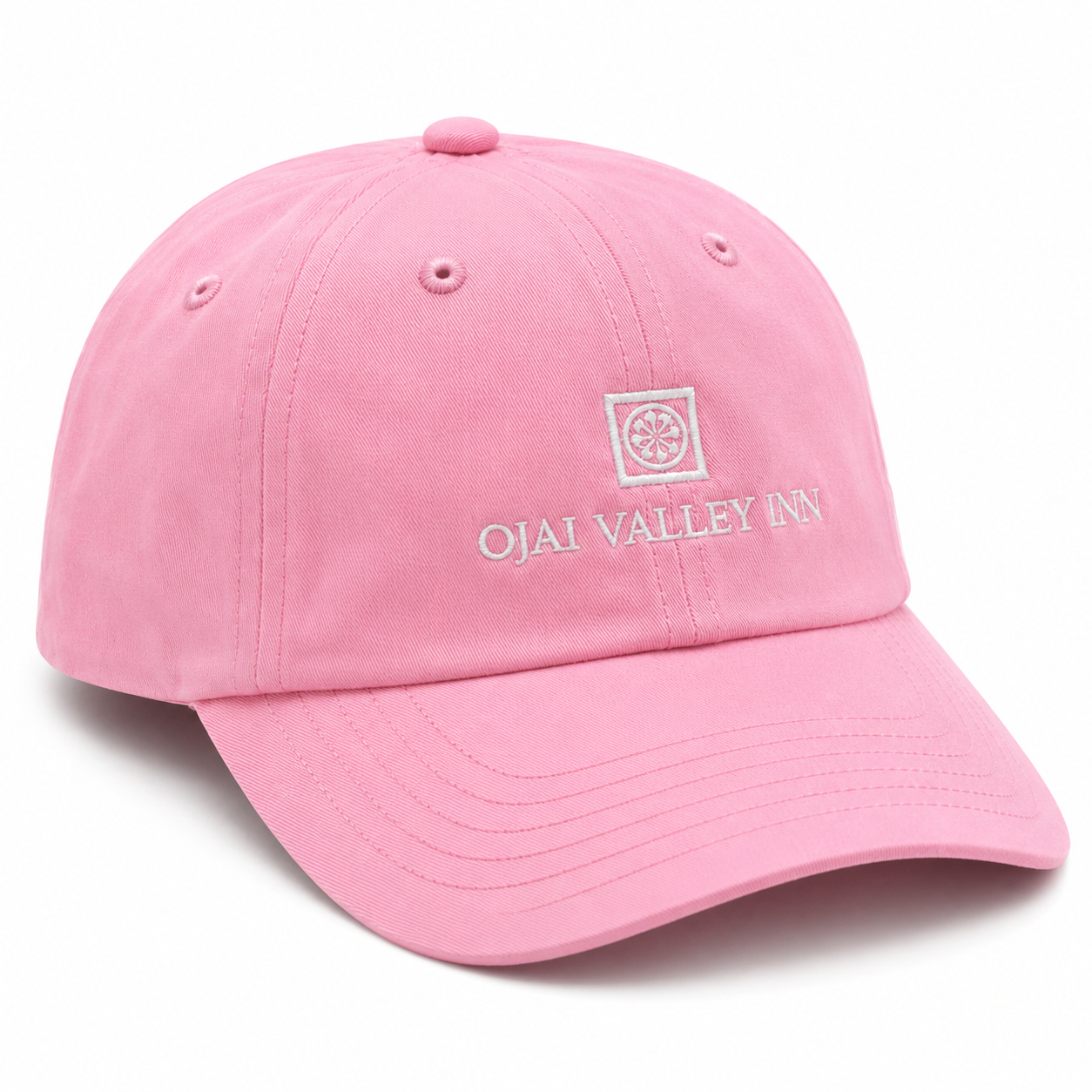 A pink cotton baseball cap with 'OJAI VALLEY INN' embroidered in white on the front, featuring a matching embroidered square logo above it.