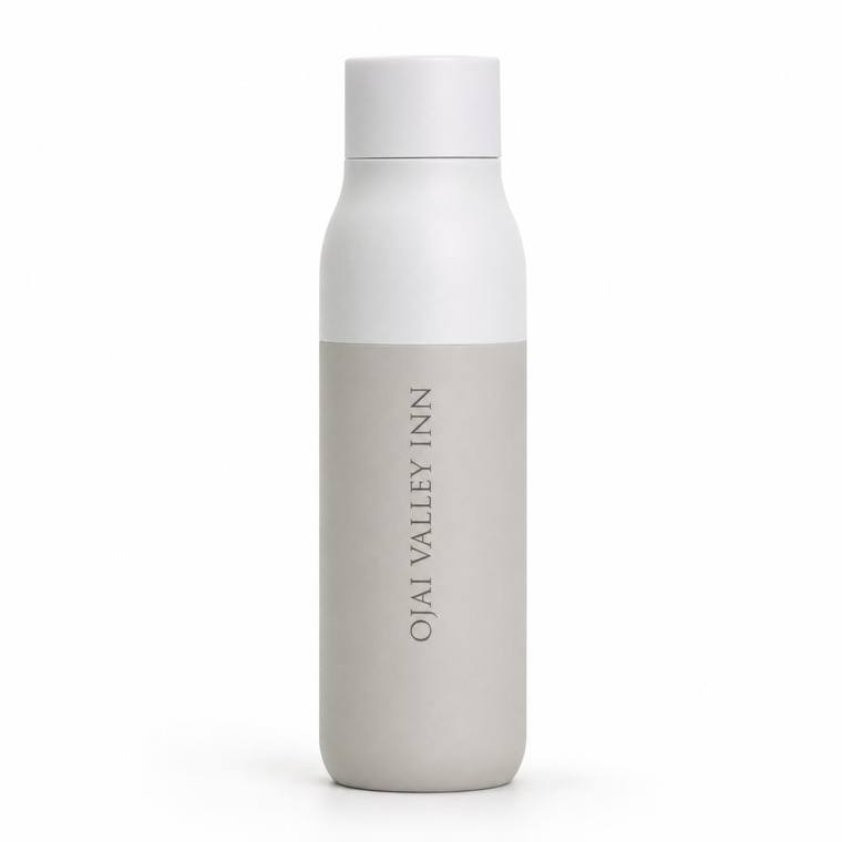 A minimalist matte bottle with a white cap and upper body, and a light gray lower section featuring the vertical text 'OJAI VALLEY INN'.