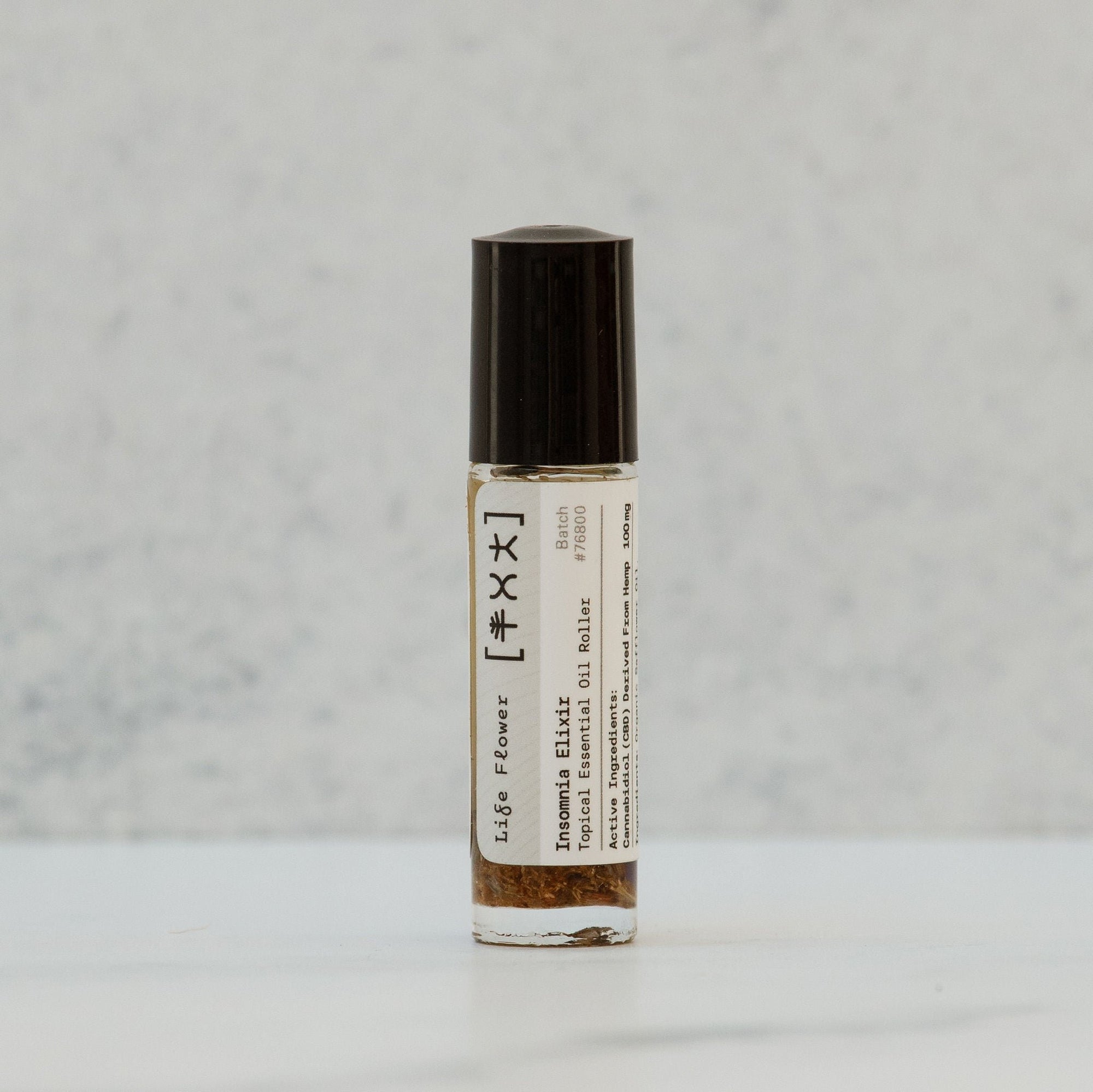 A bottle of Life Flower Insomnia Elixir with a black cap, standing upright against a light background. The label shows the product name and the word 'Elixir'.