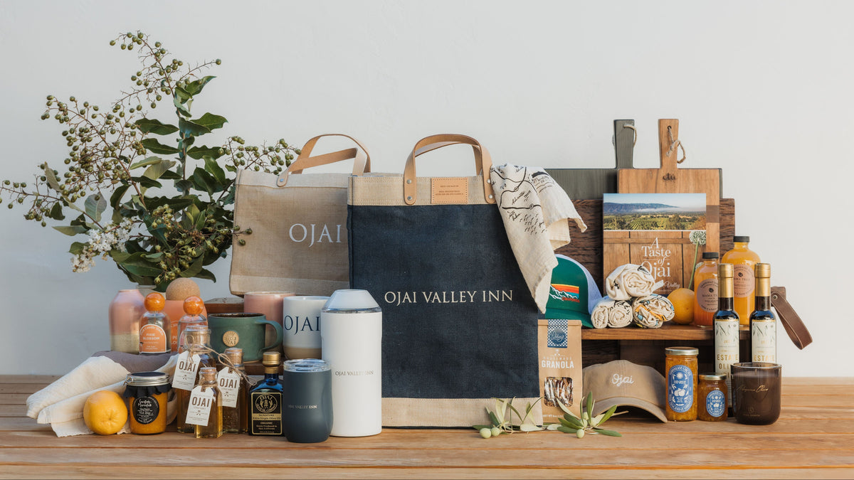 Collection of products and bags with 'Ojai Valley Inn' branding on a wooden surface.