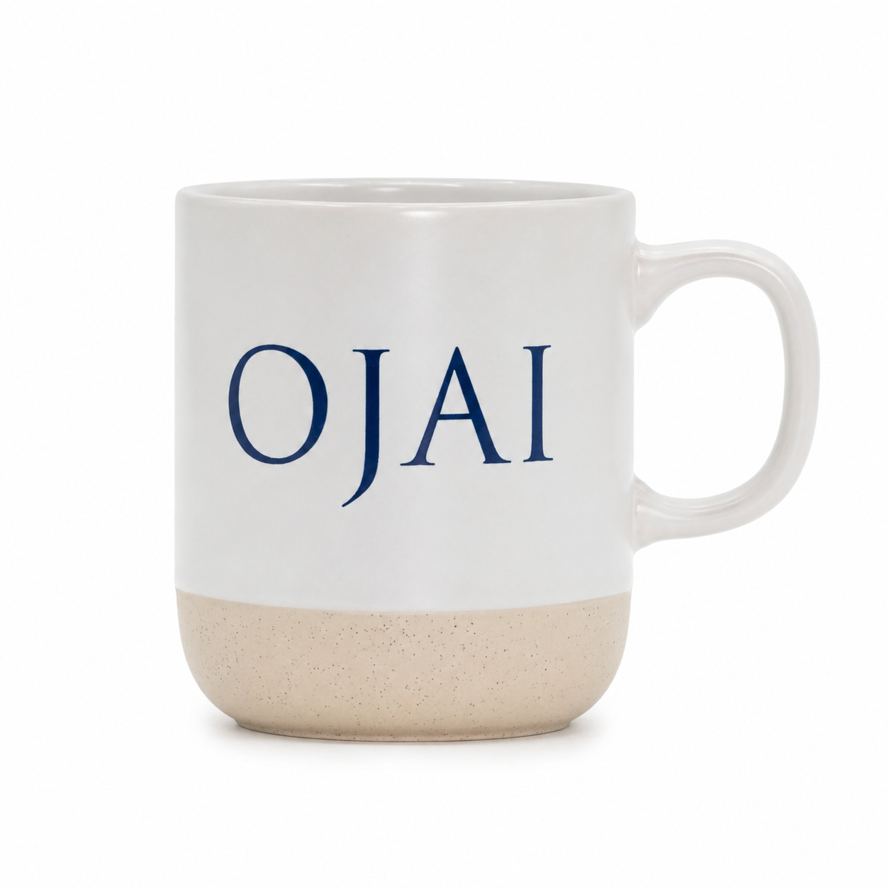A ceramic coffee mug with a white upper half, speckled beige lower half, and the word 'OJAI' printed in navy blue serif letters on the front, set against a plain white background.