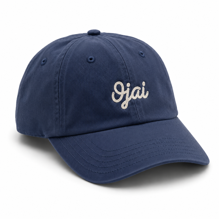 A navy blue cotton baseball cap with the word 'Ojai' embroidered in white script on the front, shown on a clean white background.