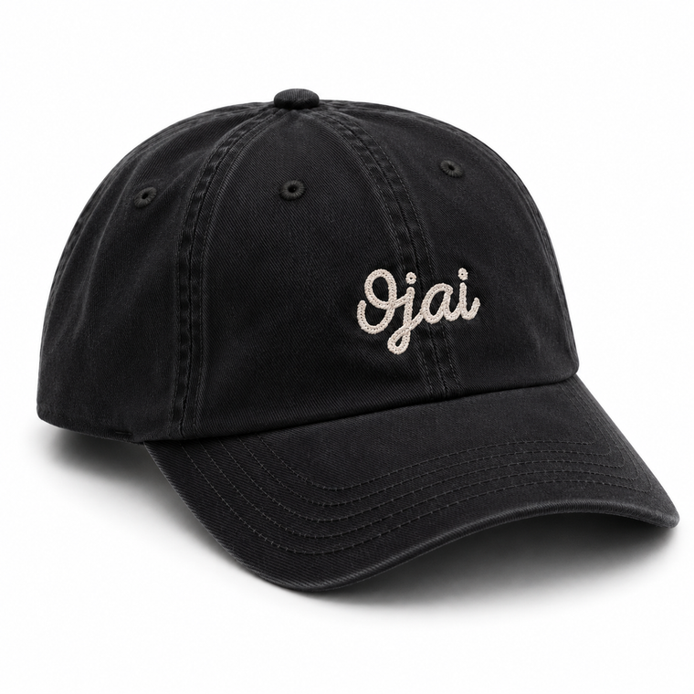 A navy washed cotton baseball cap with 'Ojai' embroidered in white script on the front, shown on a clean white background.