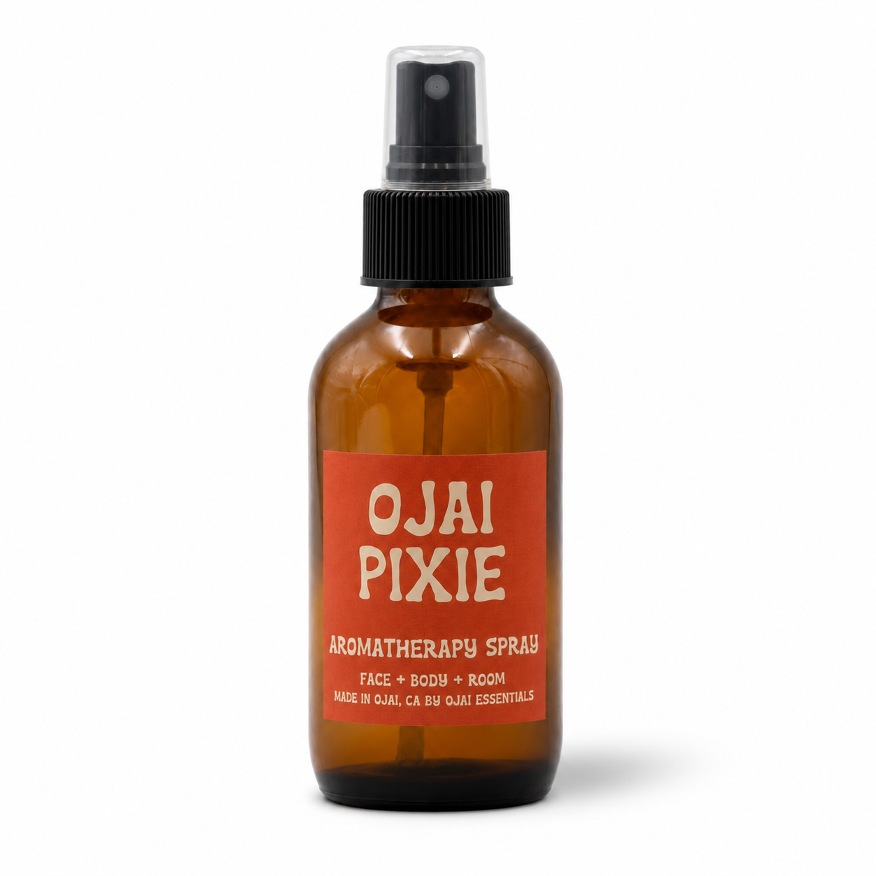 An amber glass spray bottle of Ojai Pixie Aromatherapy Spray with a black pump and a terracotta orange label, set against a plain white background.