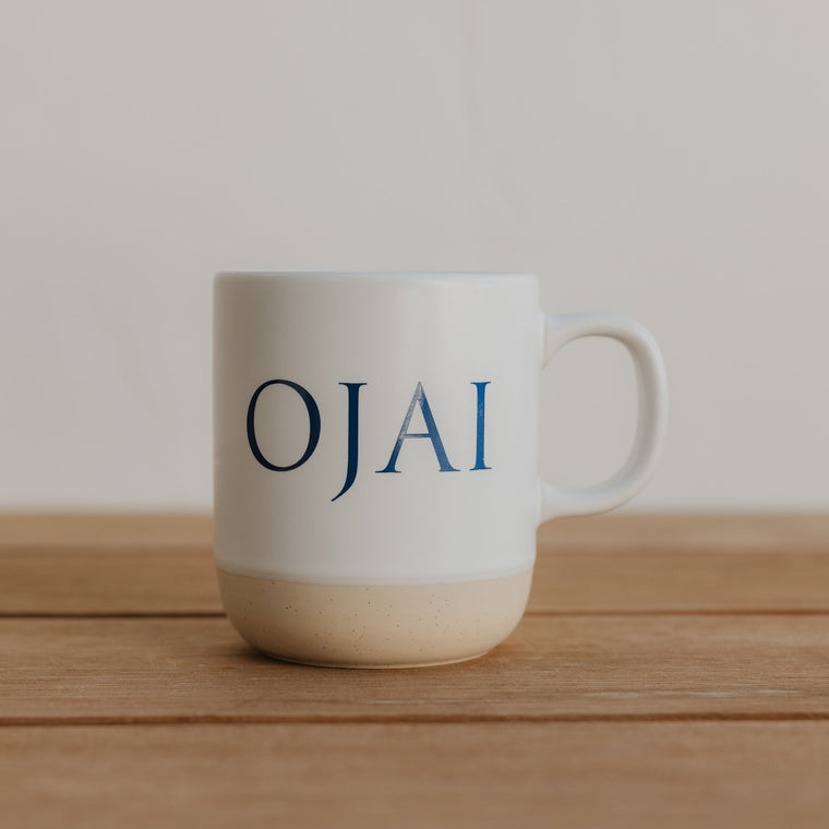 White mug with 'OJAI' text on a wooden surface