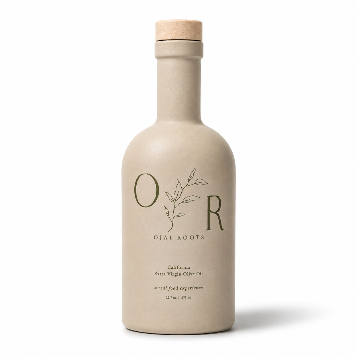 A matte beige ceramic bottle of Ojai Roots Extra Virgin Olive Oil with a natural cork stopper, shown on a clean white background.