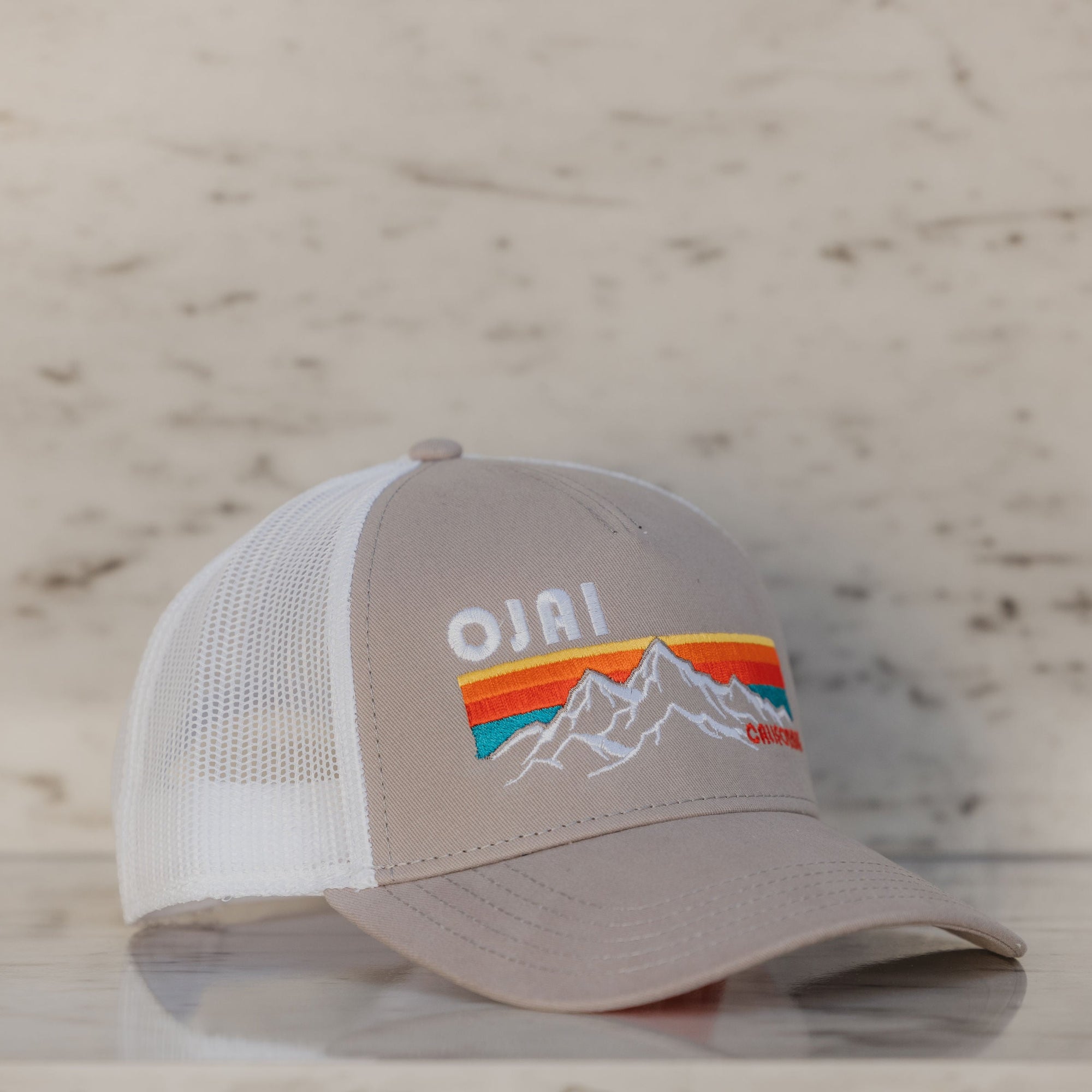 Trucker hat with 'Ojai' design on a marble surface