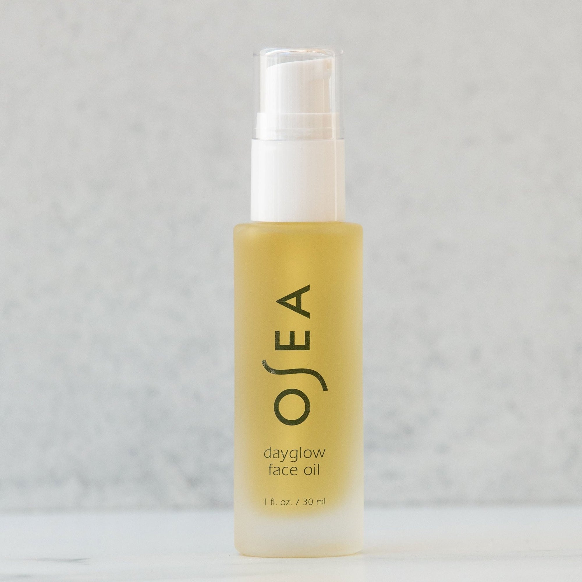 A pump bottle of OSEA Dayglow Face Oil against a neutral background.