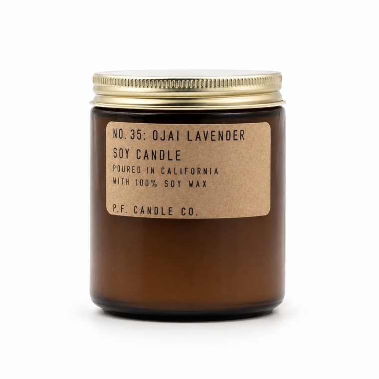 An amber glass jar candle with a gold metal screw-on lid and a kraft paper label reading 'NO. 35: OJAI LAVENDER SOY CANDLE' and 'P.