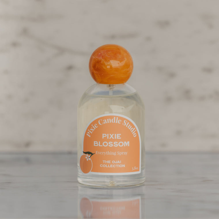 Small bottle labeled 'Pixie Blossom' with an orange cap on a marble surface.