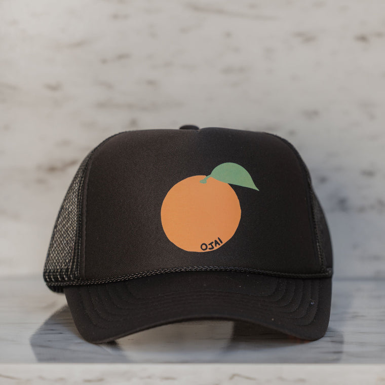 Black trucker cap with an orange logo on a light gray background
