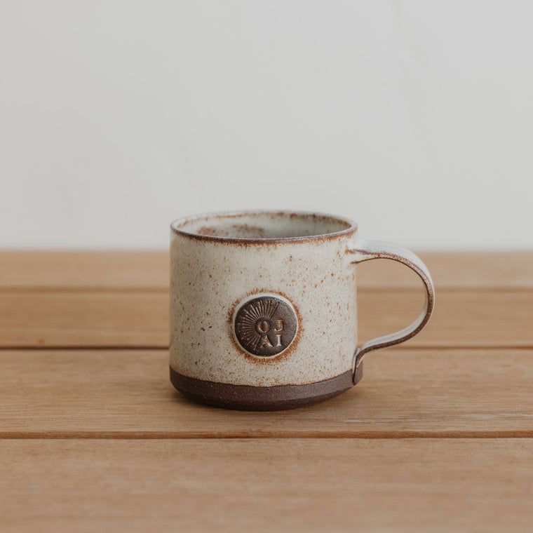 Ceramic mug with a logo on a wooden surface