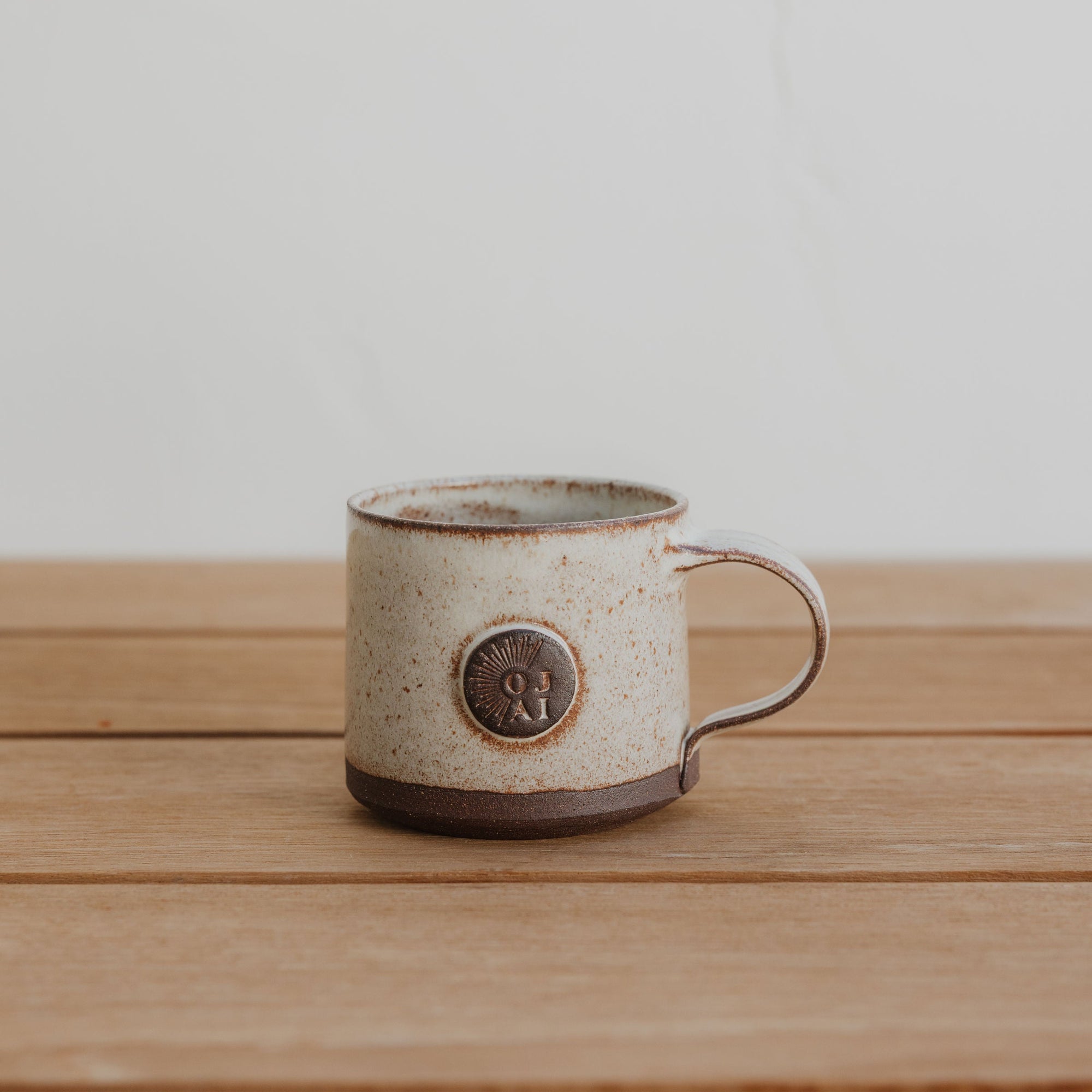 Ceramic mug with a logo on a wooden surface