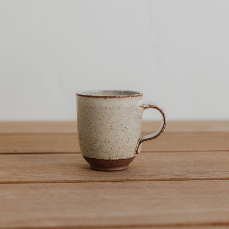 Ceramic mug on a wooden table with a plain background
