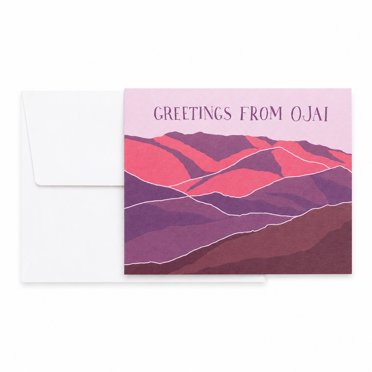 A greeting card with an envelope, featuring a stylized mountain landscape in pink, red, and purple tones with the text 'GREETINGS FROM OJAI' on a white background.