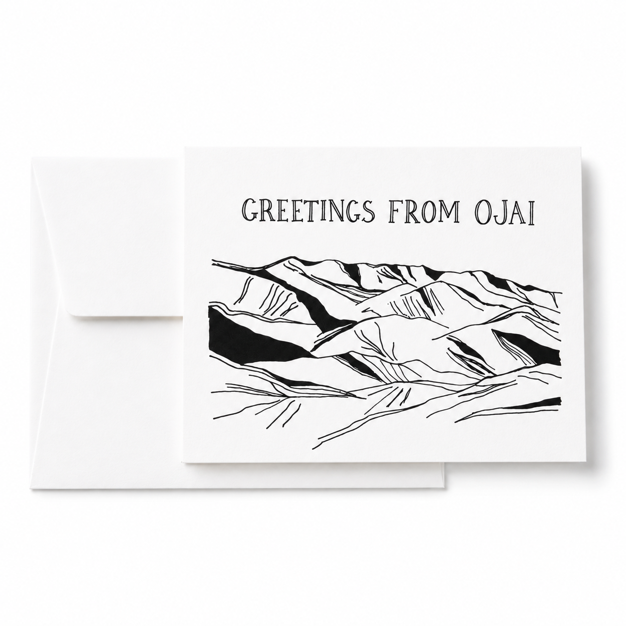A white greeting card with the text 'GREETINGS FROM OJAI' above a black line drawing of layered hills, shown with a white envelope on a light gray background.