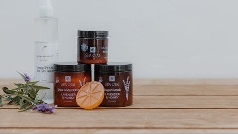 Spa Ojai skincare products on a wooden surface with a white background