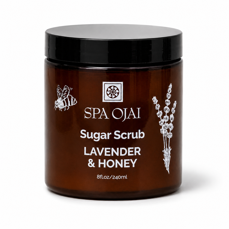 A jar of SPA OJAI Sugar Scrub Lavender & Honey in an amber brown jar with a black lid, shown on a white background.