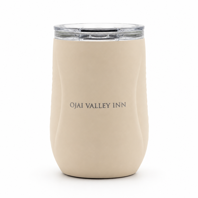 A cream-colored insulated travel tumbler with a clear lid, featuring the text 'OJAI VALLEY INN' printed in gray on the front, set against a plain white background.