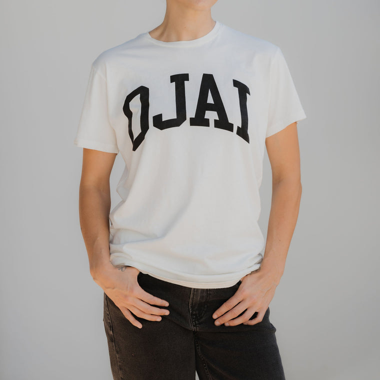Person wearing a white t-shirt with 'OJAI' printed on it against a plain background